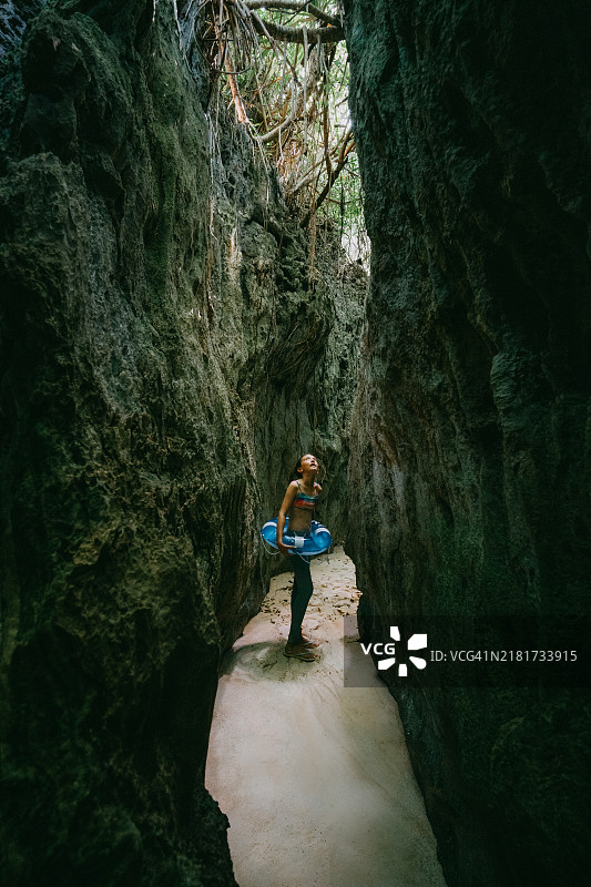 小女孩探索通往海滩的洞穴图片素材