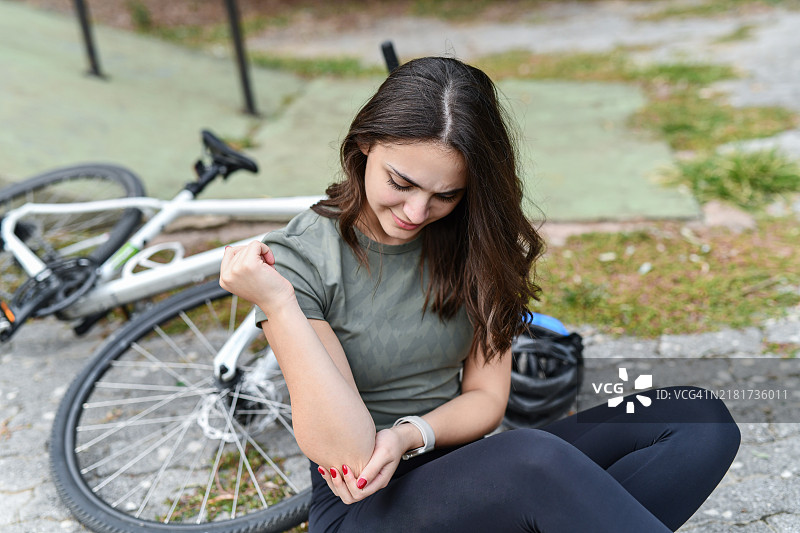 痛苦地扶着受伤胳膊的焦虑女骑手图片素材