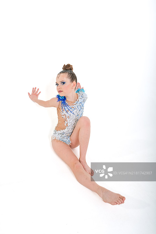 迷人的年轻女孩在白色背景下翩翩起舞的全身照图片素材