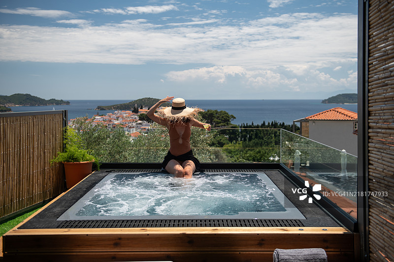侧面视角的女性在按摩浴缸中放松图片素材