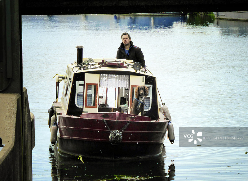男人和狗在船上图片素材