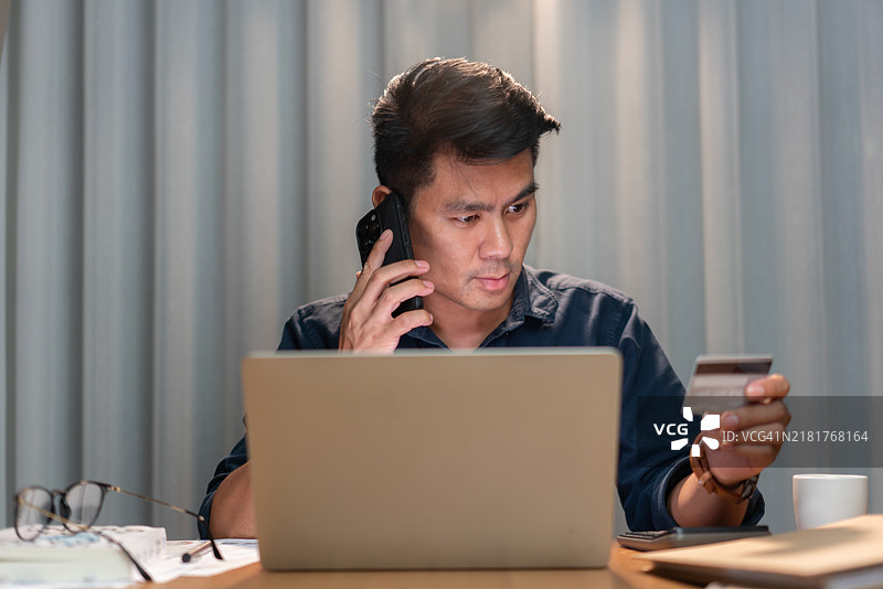 男人在打电话时进行在线支付图片素材