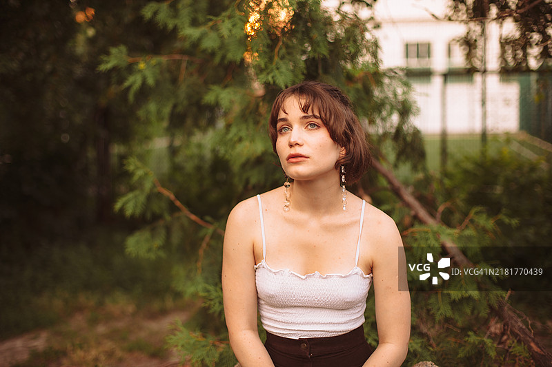 户外坐着的沉思年轻女性肖像图片素材