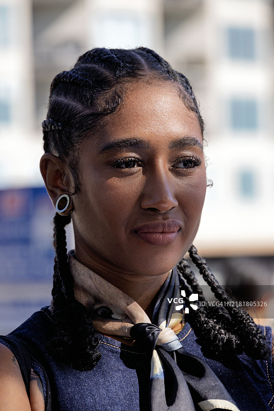 时尚女性的肖像，编着辫子，沐浴在斑驳的光影中图片素材