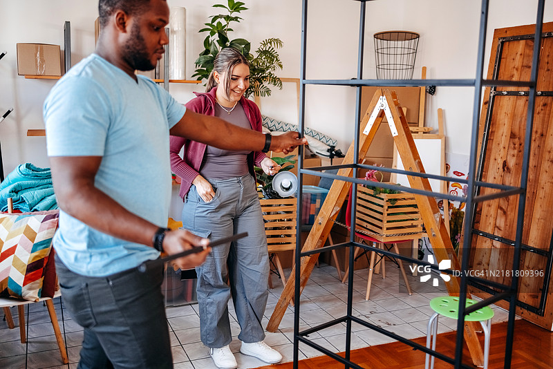 年轻夫妇在新家中组装架子图片素材