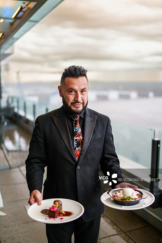 餐厅服务员在餐厅露台上展示时令甜点图片素材