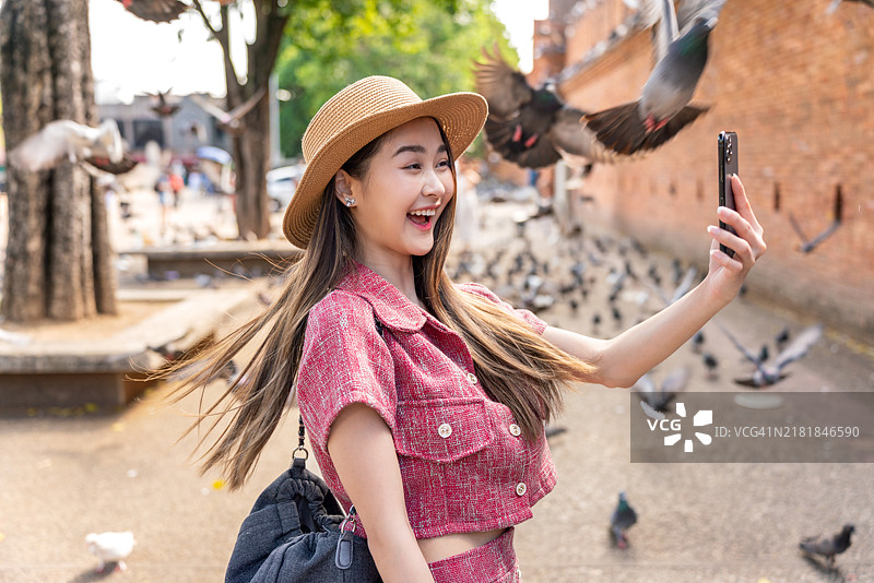 快乐的亚洲女游客在清迈古城墙附近拍照图片素材