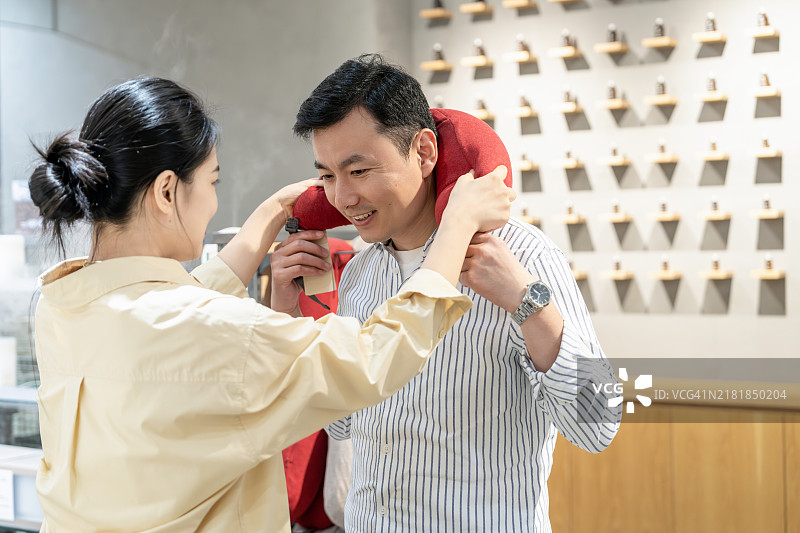 注重生活的家居必需品：一对中年亚洲夫妇在一家环保家居用品店选购U型记忆泡沫旅行颈枕。图片素材