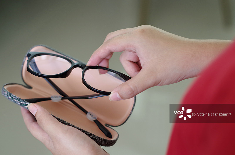 手持黑色塑料眼镜盒图片素材