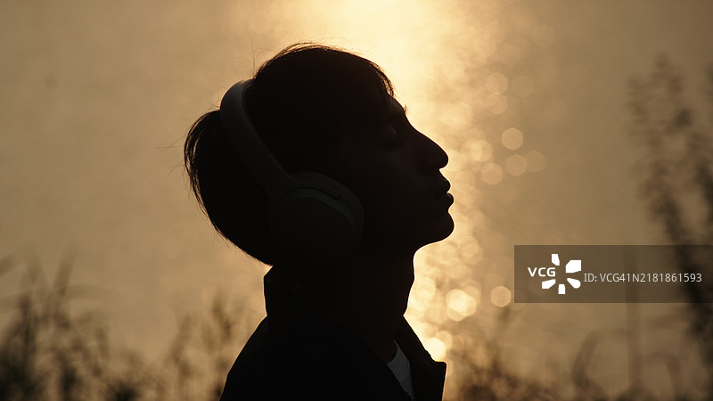 男人在河边听音乐图片素材