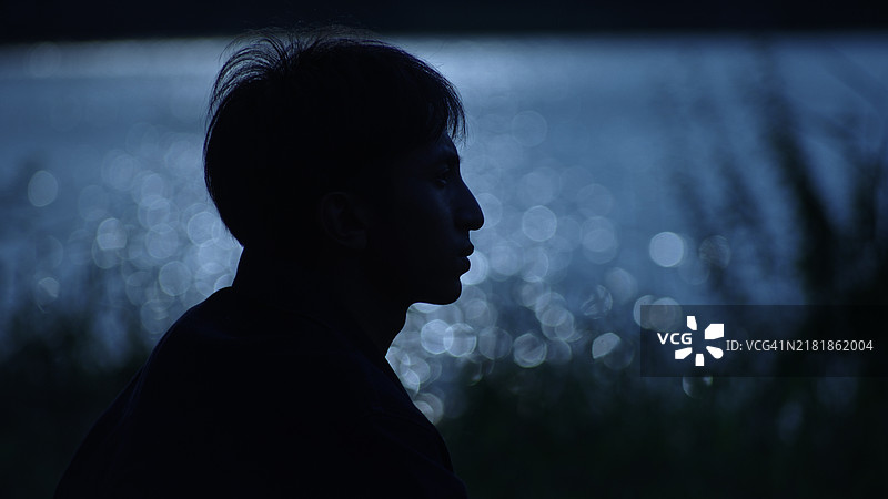 男人晚上独自在河边休息图片素材