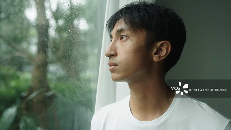 男人在家里安静地听雨图片素材