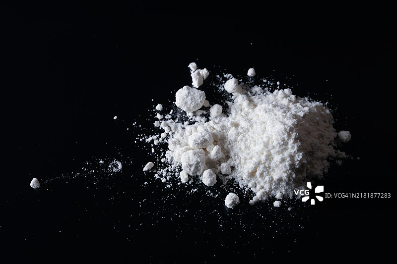 黑色表面上的一堆白色粉末图片素材