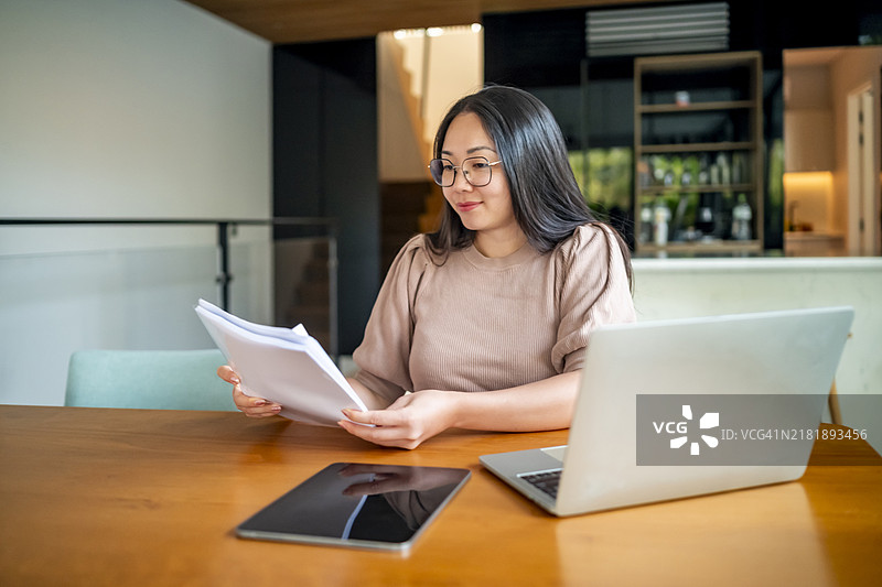 女人在家用笔记本电脑和平板电脑查看文件图片素材