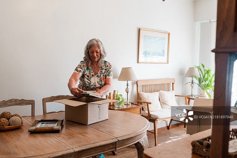 年长女性在家中拆箱子图片素材