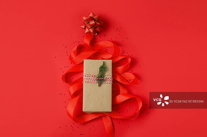 红色背景上由红色丝带和礼品组成的圣诞树图片素材