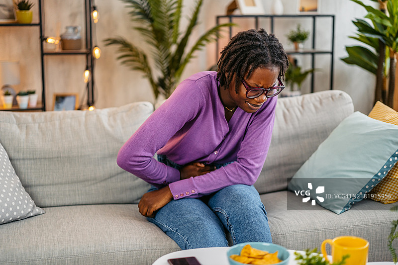 年轻女人在家肚子疼图片素材