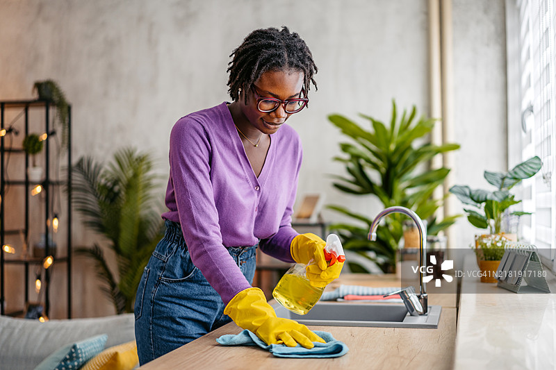 年轻女人清洁厨房台面图片素材