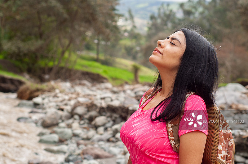 女人享受宁静的时刻，深吸新鲜的山间空气图片素材