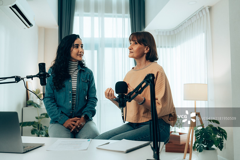 年长女性参与播客讨论，使用录音设备图片素材
