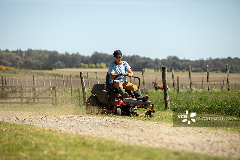 农村工人在用大型割草机割草图片素材