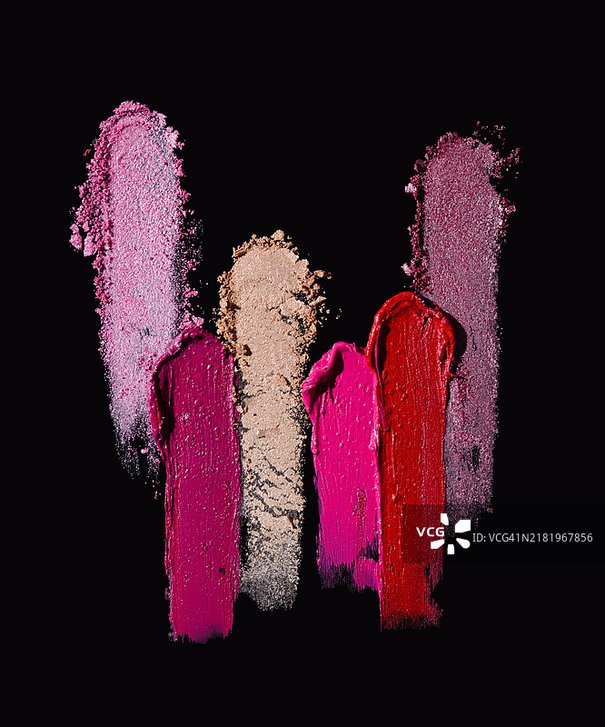 不同口红和眼影的污迹在黑色背景上图片素材