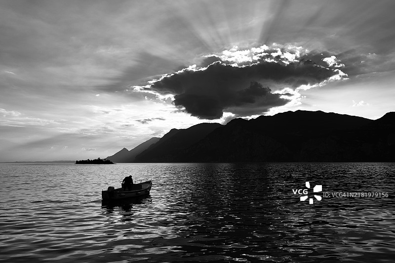 海上船中男子的剪影与天空相映图片素材