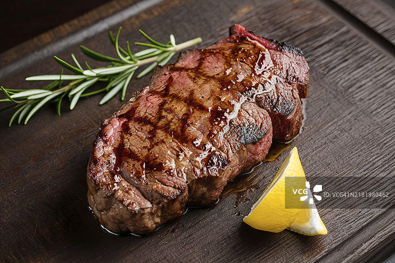 深色木质背景上的烤牛排图片素材