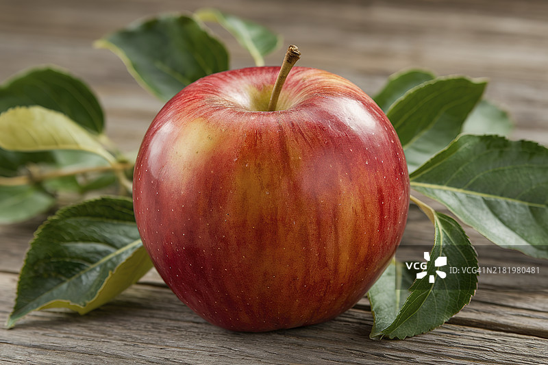 一颗成熟的红苹果，带有淡淡的红晕和顶部的小柄。图片素材