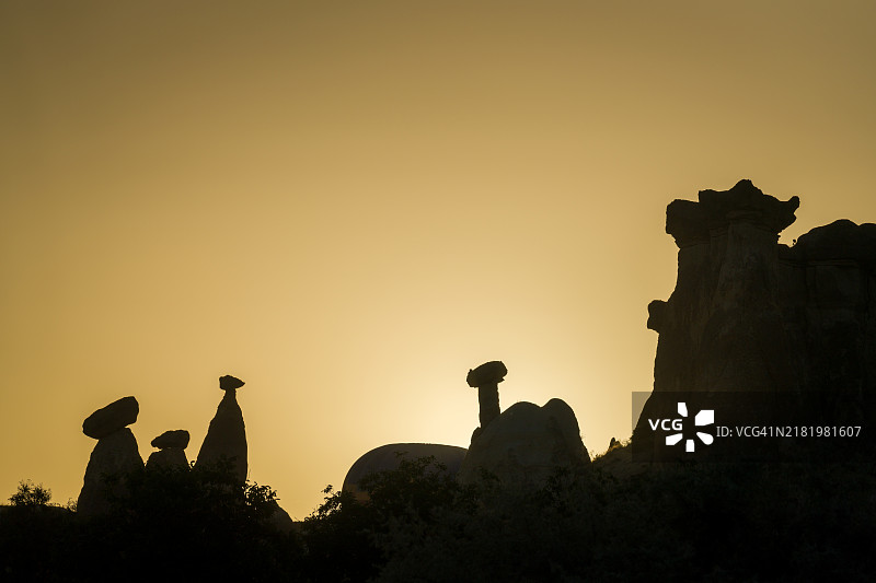 日落时分，土耳其卡帕多奇亚的天空下，岩石的剪影从低角度观察。图片素材