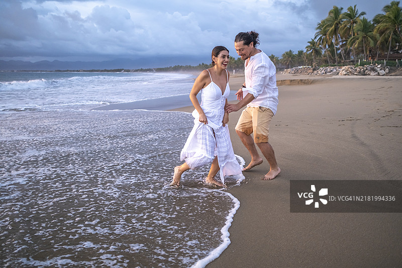 在海滩上期待宝宝到来的情侣图片素材