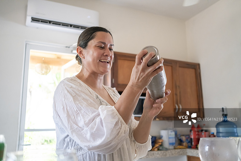 海滩上的女人在摇酒器中调制鸡尾酒图片素材