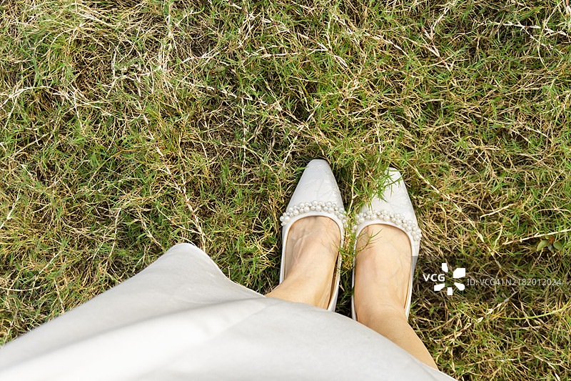 一双穿着高跟鞋的脚在户外。图片素材