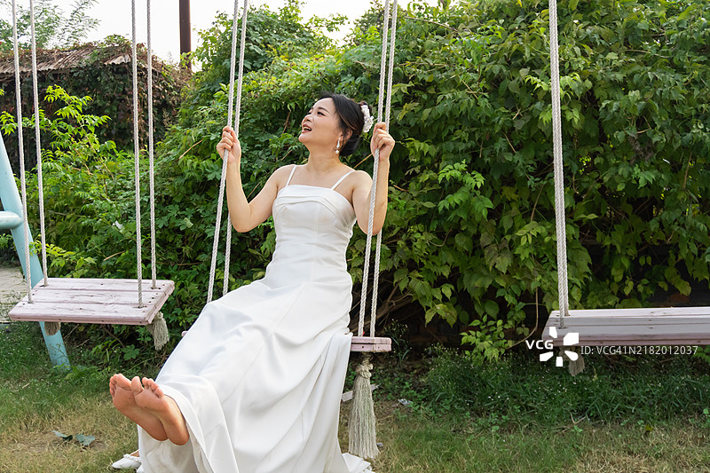 穿着白色婚纱的美丽新娘微笑着摇摆图片素材