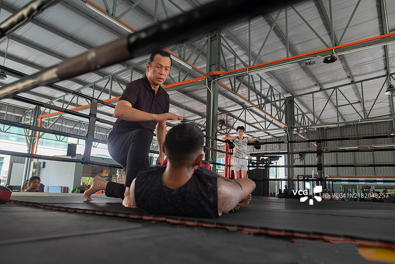 亚洲男性在健身房进行踢拳训练，胜者与败者的照片图片素材