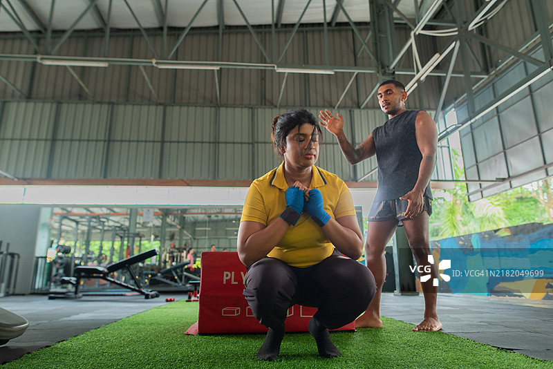 亚洲印度男性健身教练教授学生爆发力与力量的深蹲跳训练图片素材