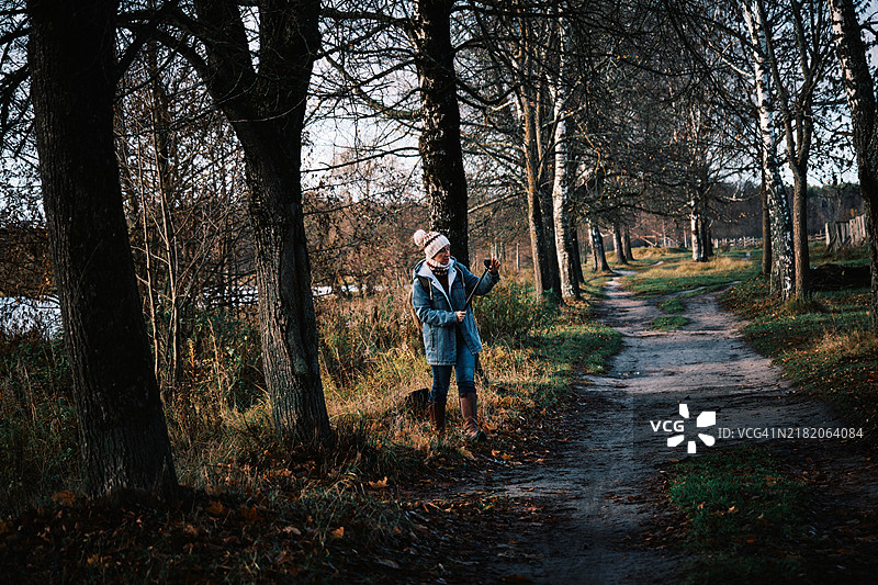 快乐的成熟的女性游客在寒冷的阳光天气中沿着十月河岸直播图片素材