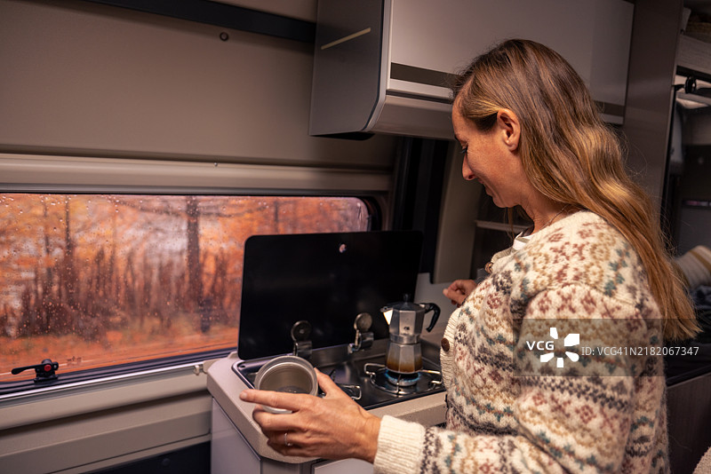 面包车里的咖啡仪式，年轻女性正在准备意大利浓缩咖啡图片素材