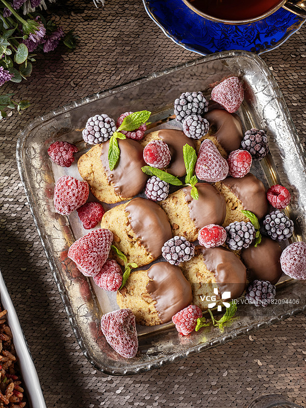 巧克力浸泡的饼干。圣诞饼干浸泡在牛奶巧克力中。牛奶巧克力浸泡的饼干。意大利脆饼，饼干。黄油饼干。浸泡在巧克力中的圣诞饼干配浆果。图片素材