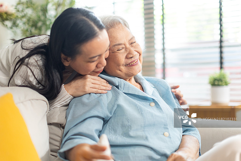 亚洲年轻女性在家中为下班后的妈妈递上一杯牛奶，关心她的健康。图片素材