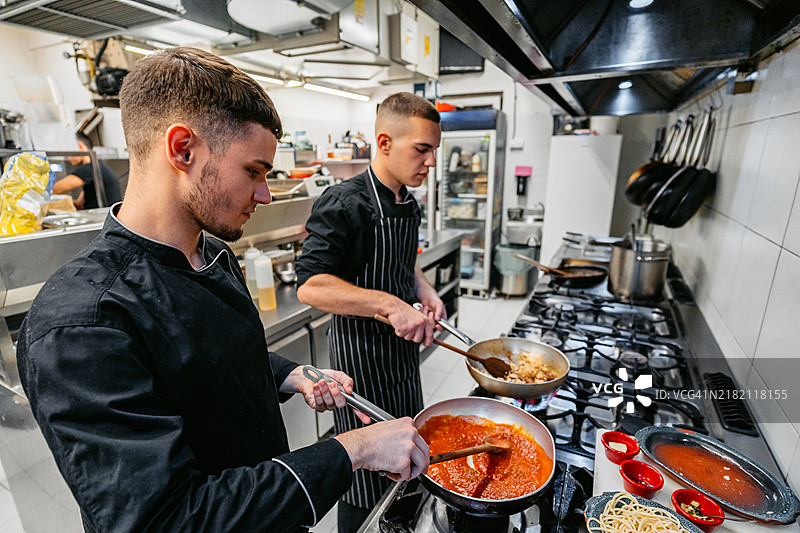 厨师和副厨师在商业厨房制作博洛尼亚意大利面图片素材
