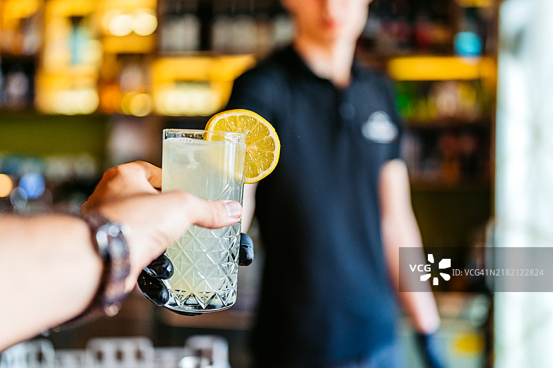 酒保在酒吧柜台上提供柠檬水图片素材