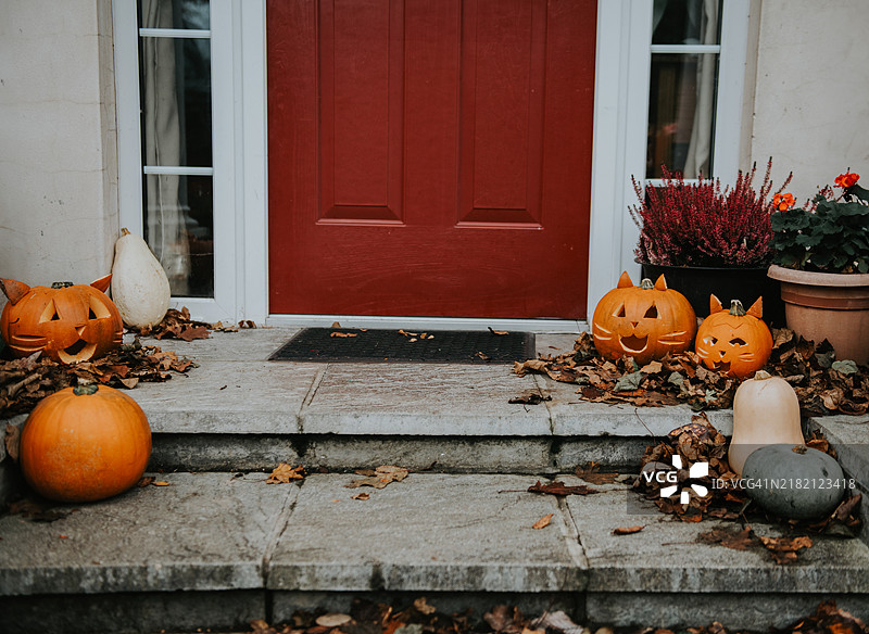 万圣节庆祝活动中，前门台阶上的猫主题雕刻南瓜灯图片素材