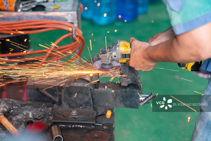 工业工人在用角磨机切割钢材图片素材