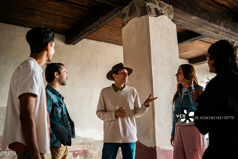 中年男导游在墨西哥特奥蒂瓦坎金字塔上与游客交谈图片素材