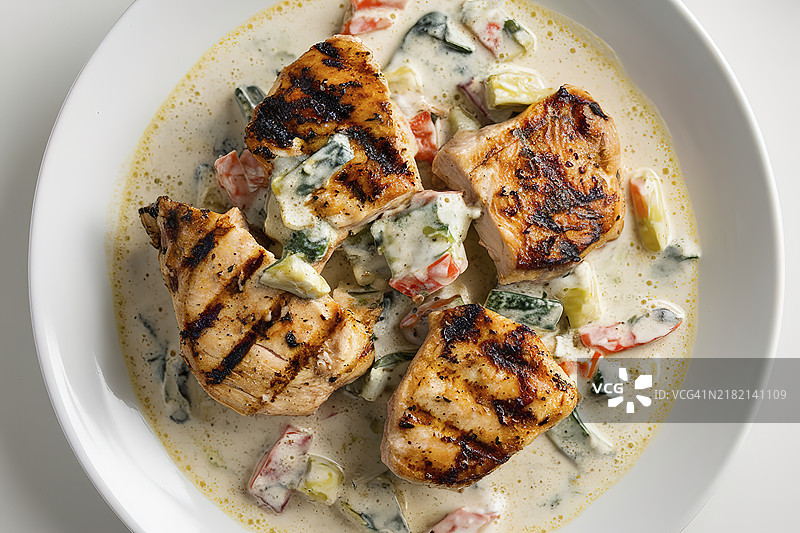 一只白色盘子里盛着烤鸡块和蔬菜奶油酱图片素材