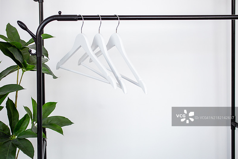 一组衣架挂在黑色栏杆上。图片素材
