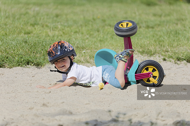 一个戴着头盔的男孩在自行车上摔倒了。波比耶沃，波兰，欧洲图片素材