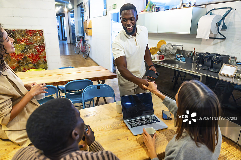 多元种族的同事们在现代共享办公空间的咖啡厅握手图片素材