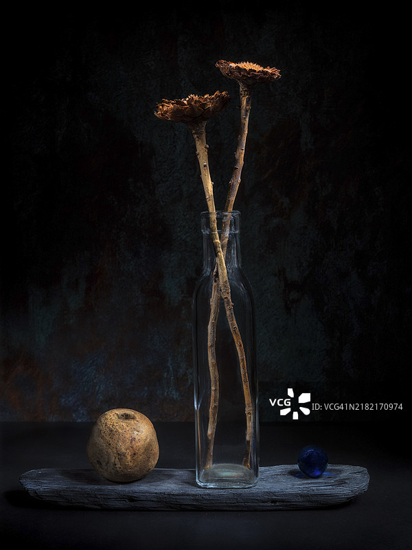 干花静物，玻璃瓶旁放着玻璃球和木球图片素材